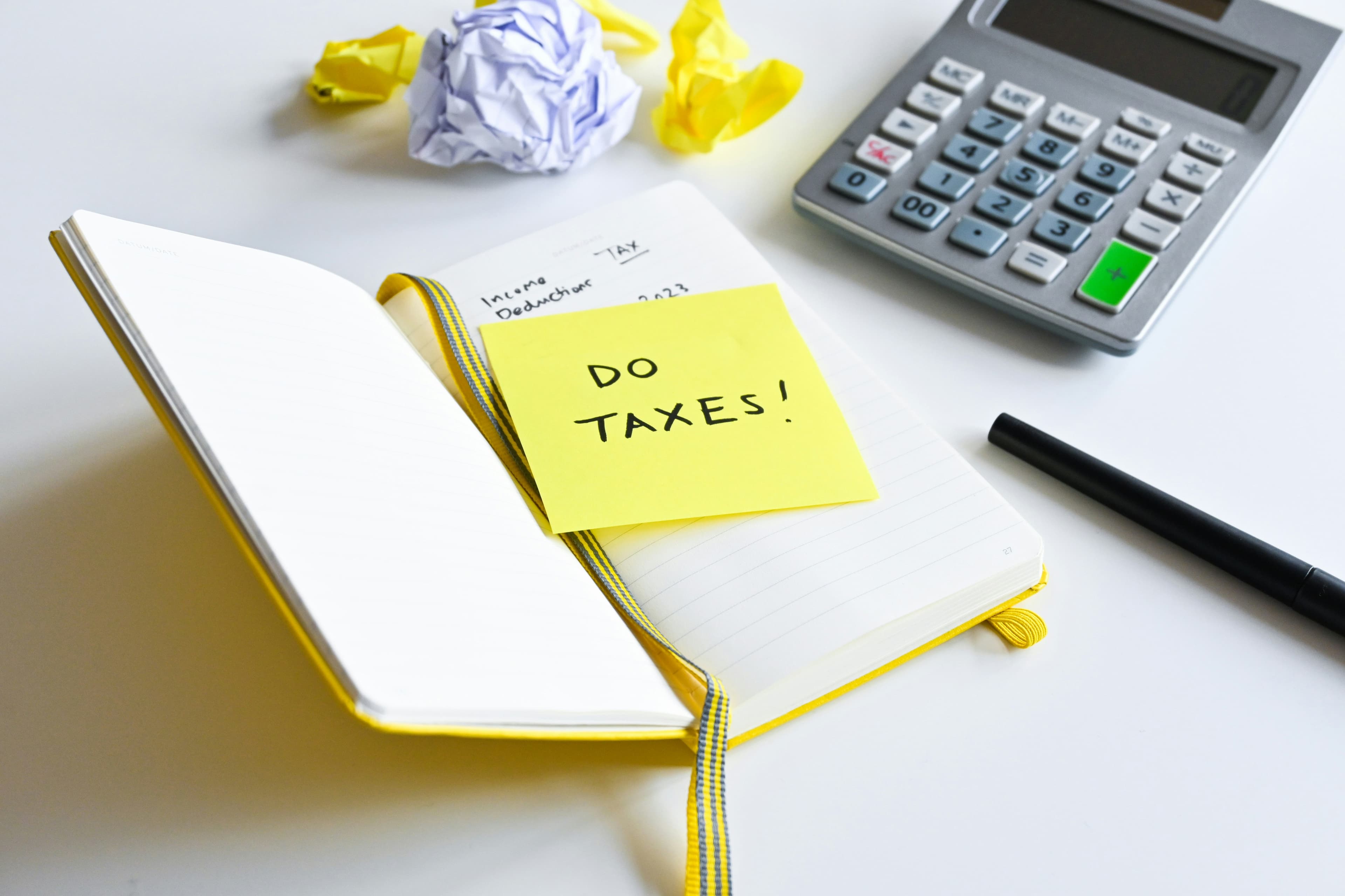 Tax planning notebook and calculator with a note that says Do Taxes!